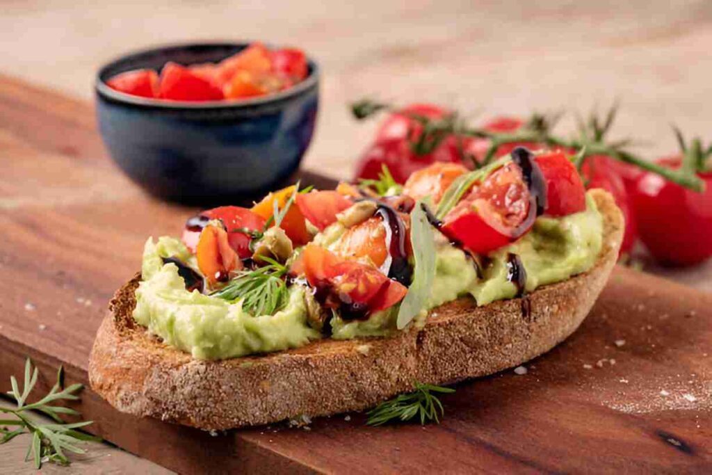 Geröstetes Brot mit Avocadobutter und Tomatensalat