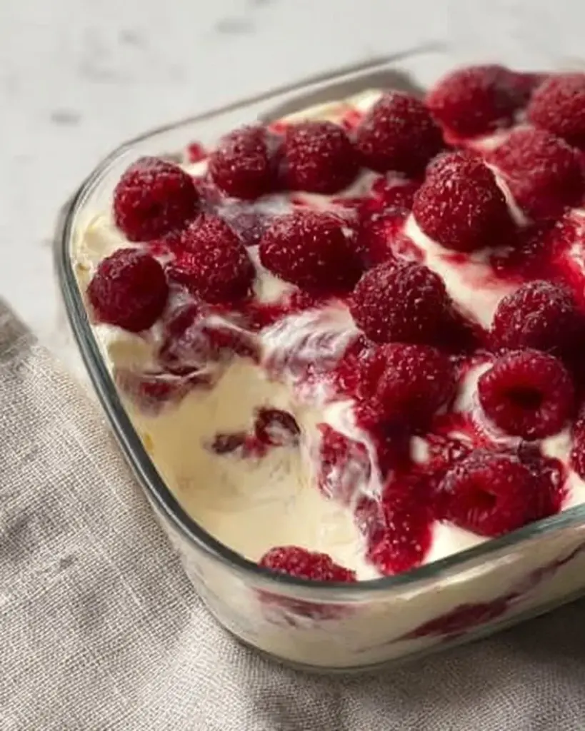 Mini Windbeutel gefüllt mit Magerquark und Himbeeren auf einem Teller