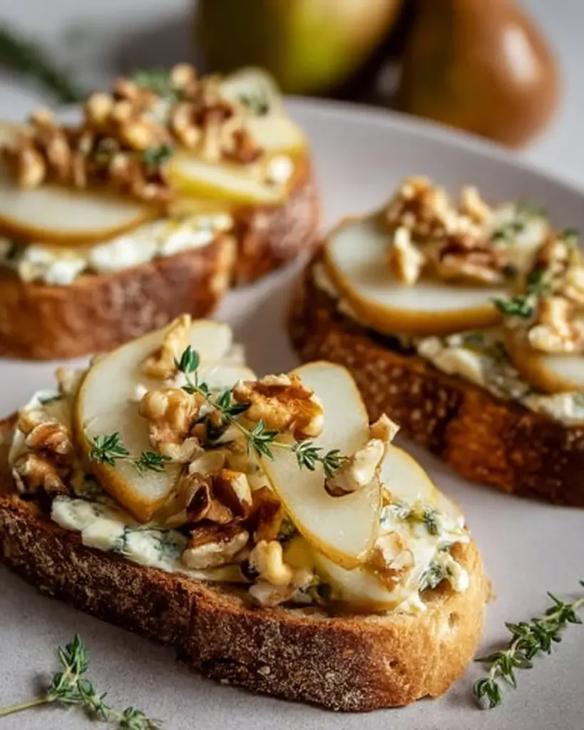 Gorgonzola-Birnen-Bruschetta auf einem Holzteller serviert.