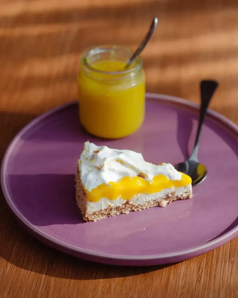 Leckerer Mango- und Passionsfruchtkäsekuchen auf einem Teller serviert.