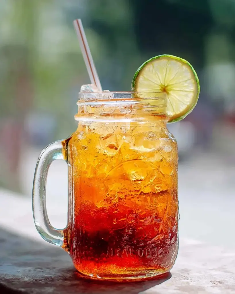 Erfrischender thailändischer Limetten-Tee in einem Glas mit Limettenscheiben